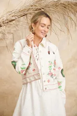 Campera de algodón color blanco con estampado de flores, plumas y colibríes, cuello camisero y cierre frontal con botones.