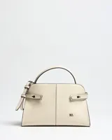 Cartera de mano color beige de diseño estructurado, con costuras verticales decorativas, manija superior y detalles de tiras con hebillas metálicas en los laterales. Incluye el logo de la marca en la parte inferior frontal.
