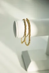 Pulsera elástica de bolitas de 3 mm en acero quirúrgico dorado.