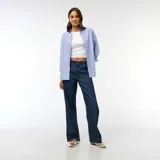Pantalón de jean con corte baggy y pierna ancha, de tiro medio y color azul oscuro, con cierre frontal y bolsillos laterales.