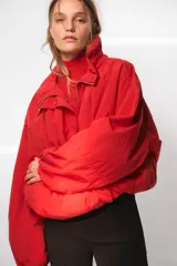Chaleco de punto sin mangas, color rojo, con cuello subido y diseño de tejido texturizado.