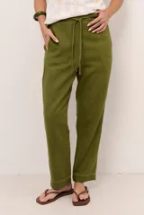 Pantalon de lino color verde militar, de corte recto y holgado, con cintura elastizada y cordón ajustable.