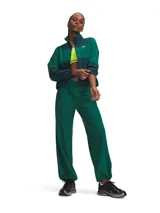Pantalón deportivo Under Armour modelo Rival Woven, de color verde oscuro, con cintura elástica con cordón y bolsillos laterales. Cuenta con tecnología UA Storm que repele el agua y tejido elástico en cuatro direcciones.
