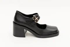 Guillerminas de cuero charol negro con punta cuadrada, taco ancho y correa sobre el empeine con doble hebilla dorada.