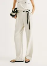 Pantalón de corte recto confeccionado en lino color beige, con cintura alta, bolsillos laterales y cinturón de cuerda ajustable con detalle de terminaciones metálicas.