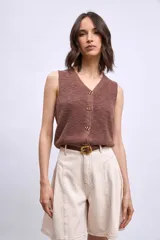 Chaleco de punto color marrón, con escote en V y cierre frontal con botones dorados.