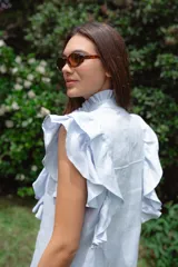 Vestido corto color verde oliva de lino con cuello mao fruncido, volados en los hombros, caída recta y botones al frente.