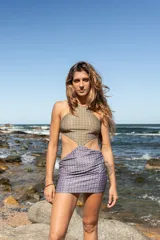 Vestido corto de estilo cut-out con escote halter, confeccionado en lycra ecofriendly con estampado geométrico en tonos verdes y azules.