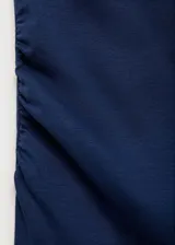Top de manga corta con cuello asimétrico y diseño entallado con detalle drapeado en la cintura.