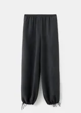Pantalón largo estilo balloon de tiro medio, confeccionado en mezcla de lyocell y poliéster, con cintura elástica, bolsillos laterales y bajo con goma elástica.