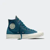 Championes Converse modelo Chuck 70 de caña alta, confeccionados en lona resistente con superposiciones de gamuza. Presentan suela de goma con acabado barnizado, puntera reforzada y el icónico parche de estrella en el lateral.