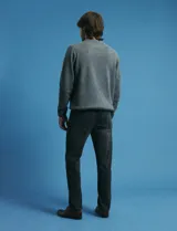 Pantalon denim de cinco bolsillos, corte recto y color negro, con botones y remaches metálicos en tono plata viejo.