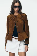 Falda pantalón blanca de tiro alto con cinturón marrón y delantero cruzado. Cierre lateral con cremallera oculta.