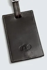 Llavero de cuero marrón con diseño rectangular, pespuntes en contraste y correa ajustable con hebilla metálica.