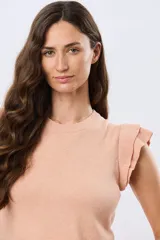 Remera tejida de algodón en color beige, de cuello redondo, sin mangas y con detalles de volados estructurados en los hombros.