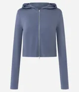 Campera corta con capucha fija, cierre frontal con cremallera y mangas largas, confeccionada en tejido modal con acabado satinado.