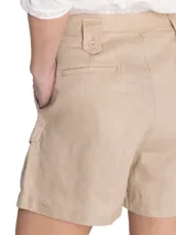 Short estilo bermuda de tiro alto de lino orgánico, color crema, con pinzas frontales y amplios bolsillos laterales con solapa y botones.