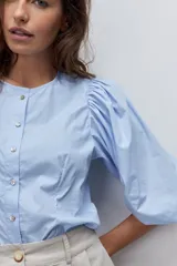 Camisa celesta de algodón con cuello mao, cierre frontal de botones y mangas abullonadas 3/4.