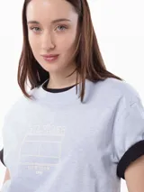 Remera celeste de algodón con cuello redondo y mangas cortas con puños negros. Estampado frontal con el logo de Tommy Hilfiger en color crema.