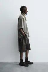 Camiseta color caqui de corte holgado, con cuello redondo y mangas cortas. Acabado con efecto lavado y ruedo irregular.