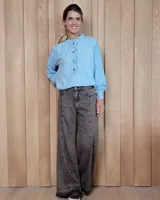 Pantalón de jean de corte wide leg, color gris oscuro con efecto lavado, con costuras verticales decorativas en el frente y ruedo deshilachado.