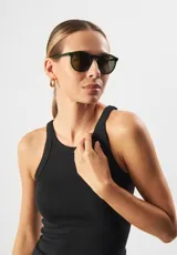 Lentes de sol redondos con montura gris translúcido y lentes verdes. Fabricados con acetato biodegradable y lentes de PMMA reciclado.