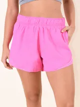 Short de running de tela liviana color fucsia, con cintura elástica fruncida y bordes redondeados con detalle de malla.