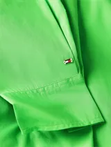Camisa verde de popelín de algodón orgánico, corte oversize con hombros caídos, cuello inglés, bolsillo de parche en el pecho y logo bordado en la manga.