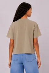 Remera manga corta de algodón color blanco, con cuello redondo y diseño holgado. Cuenta con estampado en el pecho de un paisaje de playa con palmeras en color verde.