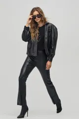 Chaqueta negra de cuero de oveja con apliques tribales en gamuza de cabra al tono, forro capitoneado de poliéster, cuello camisero redondeado, bolsillos frontales, bolsillo interno y botones metálicos a presión forrados.