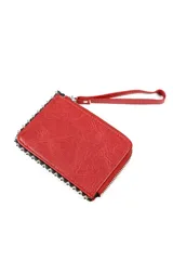 Billetera tipo clutch o monedero de color rojo, con textura de cuero sintético y cierre perimetral de cremallera. Presenta una correa de mano desmontable y está decorada con tachas metálicas plateadas alrededor del borde.