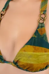 Top de bikini triangular con estampado abstracto en tonos verde y mostaza, con tirantes anudados al cuello y a la espalda, y argollas metálicas doradas en las uniones de los breteles.