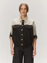 Chaquetas de lino bicolor en tonos blanco y beige, con diseño holgado, cuello alto, cierre frontal de botones, bolsillos con solapa en el pecho y mangas cortas con presilla y botón.