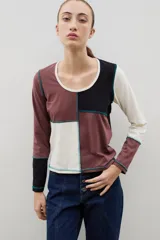 Remera de manga larga con diseño de bloques de color en tonos neutros, confeccionada con costuras externas visibles en color azul contrastante.