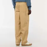 Pantalón de sarga color beige, de corte ancho y tiro alto, con cierre frontal y bolsillos laterales.