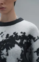 Sweater de punto con diseño abstracto tipo tie-dye o manchado en tonos gris y negro, de cuello redondo, manga larga y corte oversize. Presenta terminaciones en punto rib en cuello, puños y ruedo.