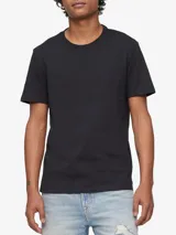 Remera de algodón lisa color negro, de manga corta, con cuello redondo y discreto monograma bordado de la marca Calvin Klein en el pecho.