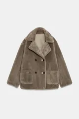 Abrigo reversible de corte recto con cuello solapa, manga larga y cierre frontal de doble botonadura. Presenta un diseño de efecto pelo en un lado y efecto piel en el reverso, con bolsillos de plastrón en el frente.
