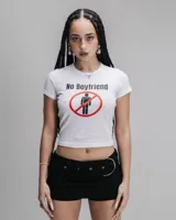 Remera corta blanca de algodón con cuello redondo y mangas cortas. Estampado frontal con la frase "No Boyfriend" y un pictograma de un hombre dentro de un círculo rojo tachado.