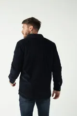 Chaqueta marrón de pana con cuello clásico, cierre frontal con botones, bolsillos con solapa abotonados en el pecho y bolsillos laterales. Interior capitoneado en azul.