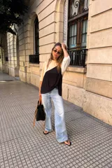 Remerón de manga tres cuartos con diseño tricolor en bloques diagonales: negro en el centro, beige claro en la parte superior izquierda y blanco en la manga derecha.