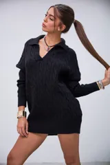 Sweater negro de punto trenzado, con cuello polo y escote en V. Diseño holgado y largo hasta la mitad del muslo.