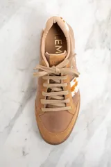 Zapatillas bajas color marrón con detalles en cuero con estampado de vaca en los laterales y talón.