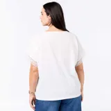 Camiseta blanca de manga corta holgada, con detalles de bordado y macramé en las mangas y cuello redondo.
