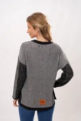 Sweater de punto con cuello redondo y mangas largas. Diseño a rayas verticales en tonos gris y negro.