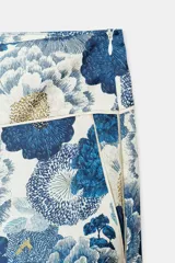 Pantalón de tiro medio con bolsillos laterales ocultos y pernera ancha, confeccionado con un vistoso estampado floral en tonos azules y blancos. Cuenta con cierre de cremallera lateral oculta en la costura.