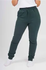 Pantalón de jogging unisex de felpa, color verde oscuro, con cintura elástica con cordón de ajuste y puños elásticos en los tobillos.