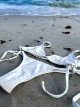 Bombacha de bikini blanca de lycra, corte colaless, con tiras laterales para atar.