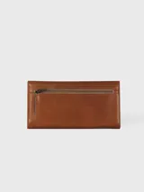 Billetera combinada de cuero en tonos marrón y camel, con solapa frontal de pelo vacuno estampado y detalle de placa con el logo de la marca.