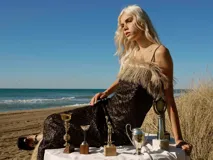 Vestido largo de lentejuelas con escote recto y detalles de rafia en el escote y el dobladillo.